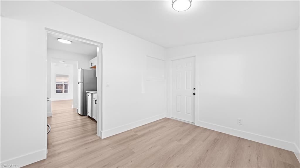 105 Oregon Road North Lehigh Acres, FL 33936 - Photo 16 of 17 Unfurnished room featuring baseboards and light wood-type flooring