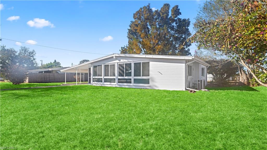 105 Oregon Road North Lehigh Acres, FL 33936 - Photo 17 of 17 Rear view of house with a sunroom
