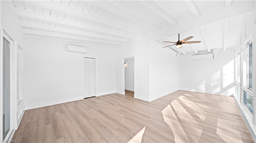 105 Oregon Road North Lehigh Acres, FL 33936 - Photo 7 of 17 Unfurnished living room with light wood-type flooring, a ceiling fan, and lofted ceiling with beams