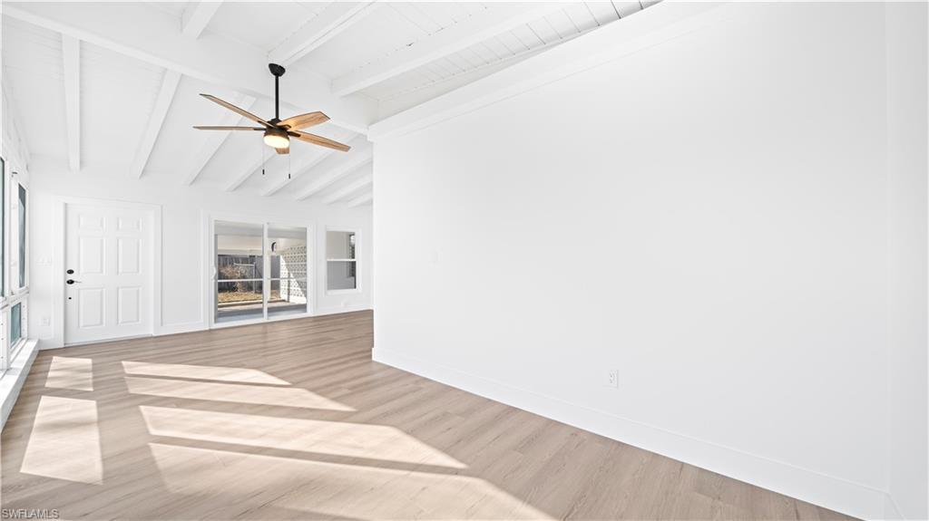 105 Oregon Road North Lehigh Acres, FL 33936 - Photo 10 of 17 Unfurnished living room featuring ceiling fan, light wood-style flooring, and lofted ceiling with beams