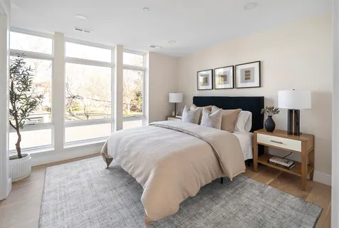 a bedroom with a bed and a large window