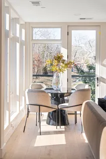 a living room with stainless steel appliances kitchen island granite countertop a table chairs sink and cabinets