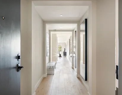 a view of a hallway with wooden floor and closet