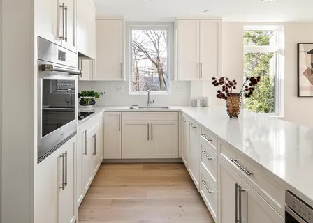 a kitchen with white cabinets and sink