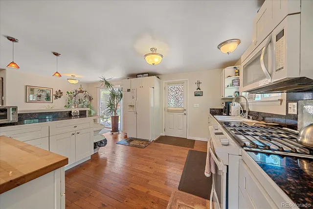 a kitchen with cabinets and wooden floor