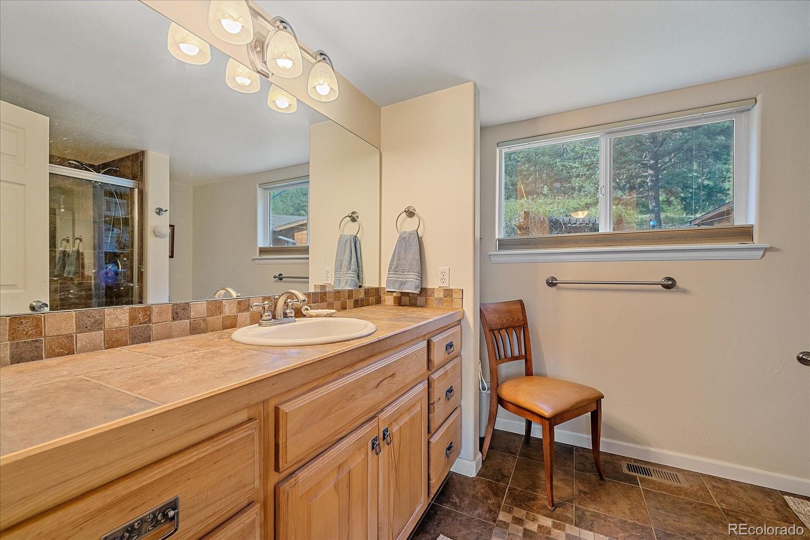 357 County Road 64 Shawnee, CO 80475 - Photo 15 of 50 a bathroom with a sink a chair and a large mirror