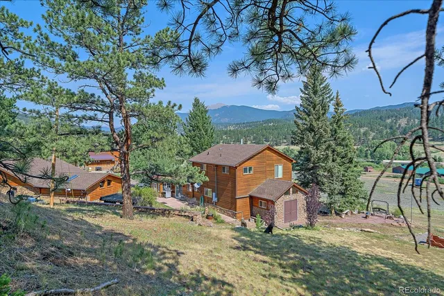 an aerial view of a house with a garden and trees