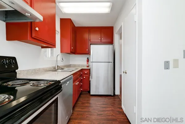 a kitchen with a stove a refrigerator and cabinets
