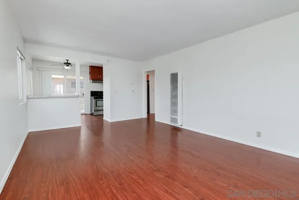 a view of empty room with wooden floor and fireplace