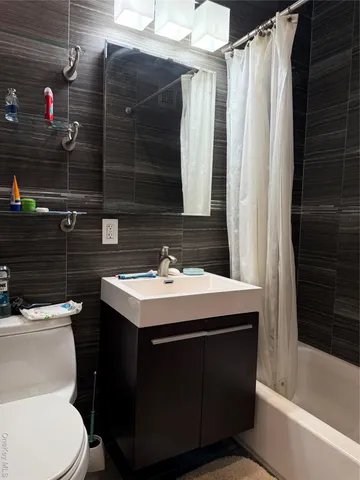 a bathroom with a sink toilet vanity and shower
