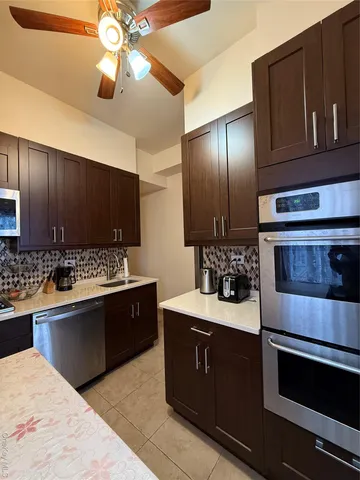 a kitchen with stainless steel appliances kitchen island granite countertop a sink stove and refrigerator