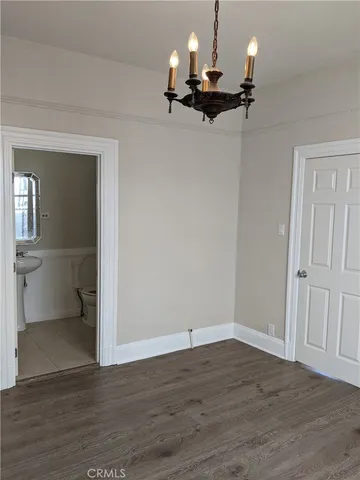 a view of a room with a fireplace wooden floor and chandelier