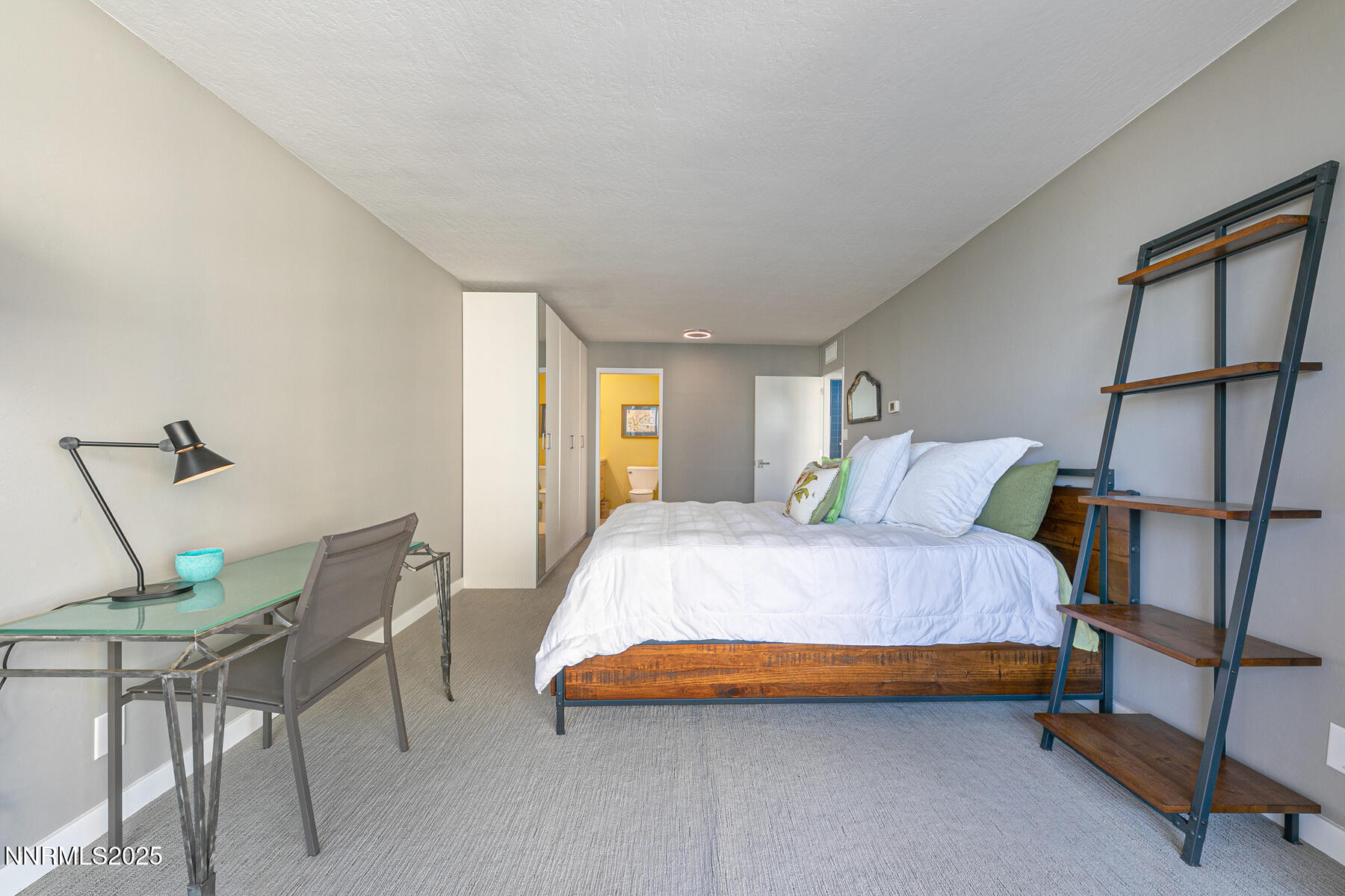 100 North Arlington Avenue, Unit 7K Reno, NV 89501 - Photo 18 of 28 a spacious bedroom with a bed and chair