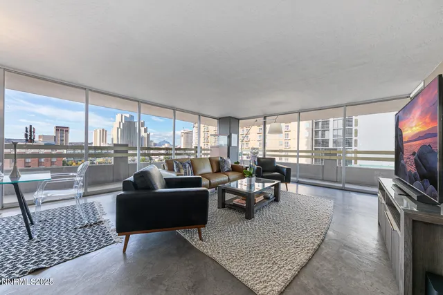 a living room with furniture a large window and a flat screen tv