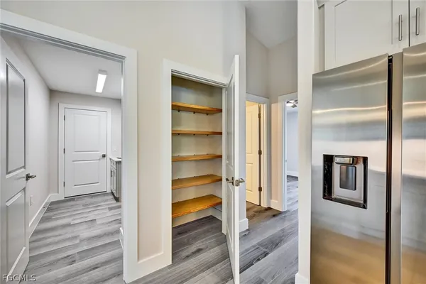 a view of a hallway with wooden floor and staircase