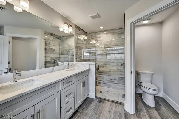 an empty room with wooden floor closet and windows
