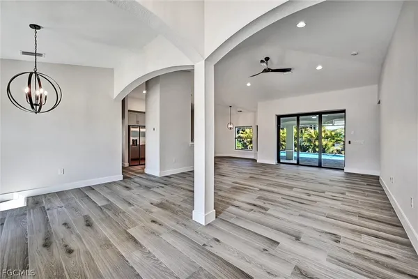 a view of empty room with wooden floor and window