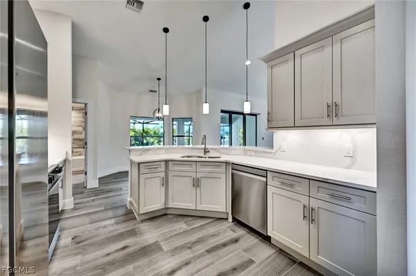 a kitchen with white cabinets and sink