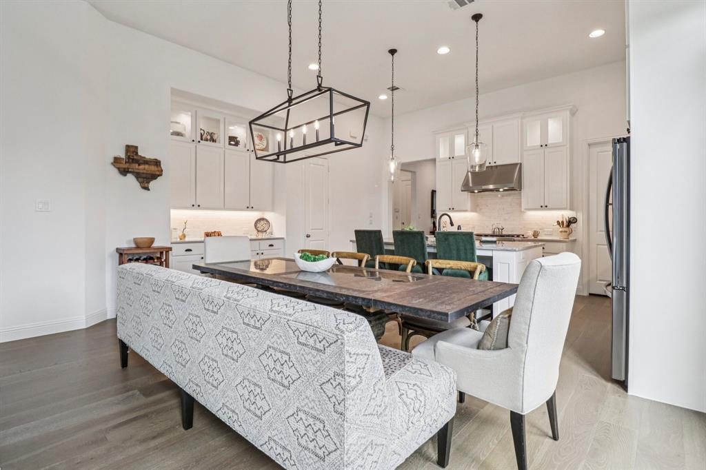 8277 Halifax The Colony, TX 75056 - Photo 9 of 37 a room with stainless steel appliances kitchen island granite countertop a table chairs and a wooden floor