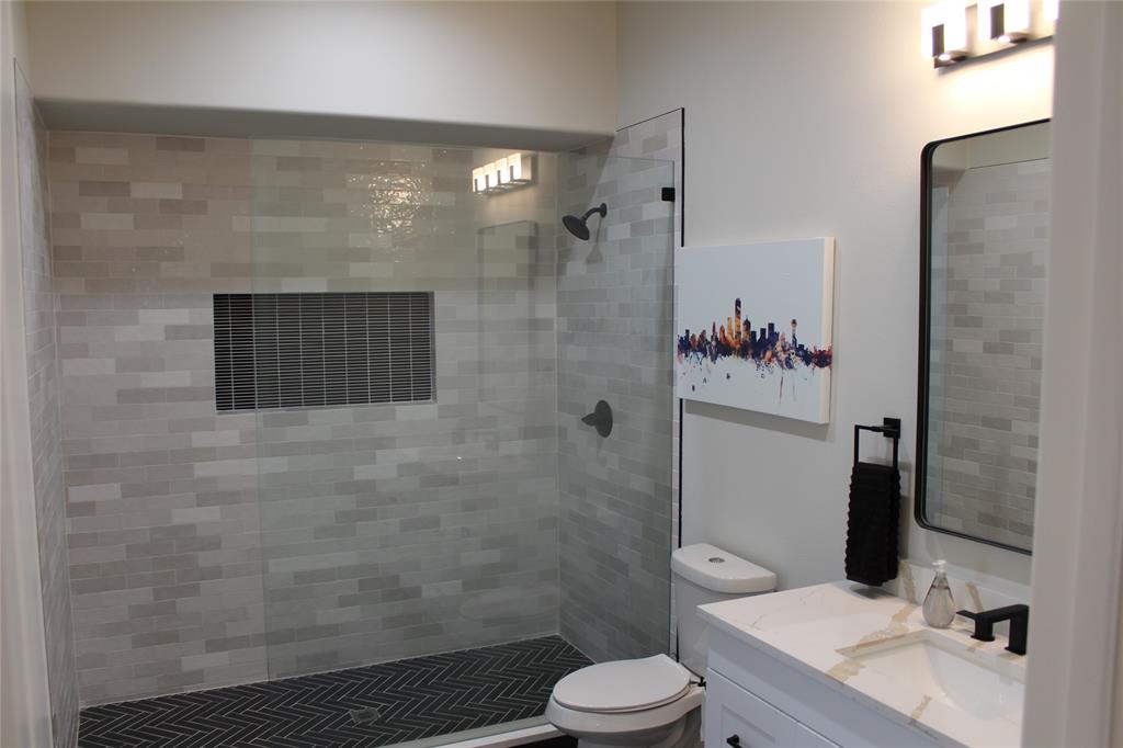 333 Renaissance Lane Heath, TX 75032 - Photo 27 of 35 Shower with glass enclosure, light grey subway tile walls, and a dark herringbone tile floor