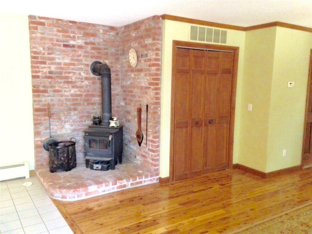 247 Nicholas Road Coventry, RI 02827 - Photo 16 of 34 WOOD BURNING STOVE IN BETWEEN BOTH KITCHEN AND DINING ROOM