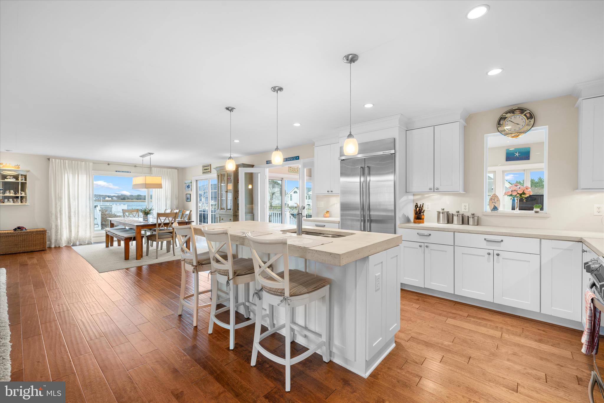 30 Marshall Road Rehoboth Beach, DE 19971 - Photo 13 of 77 a open kitchen with stainless steel appliances granite countertop a stove a refrigerator a kitchen island a dining table and chairs with wooden floor