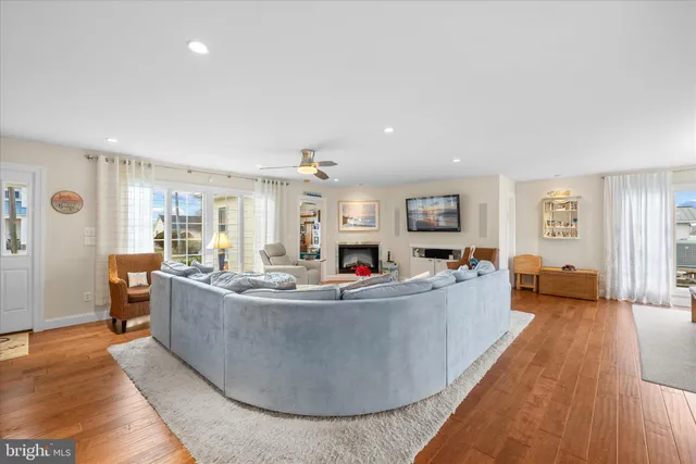 a open kitchen with stainless steel appliances granite countertop a stove a refrigerator a kitchen island a dining table and chairs with wooden floor