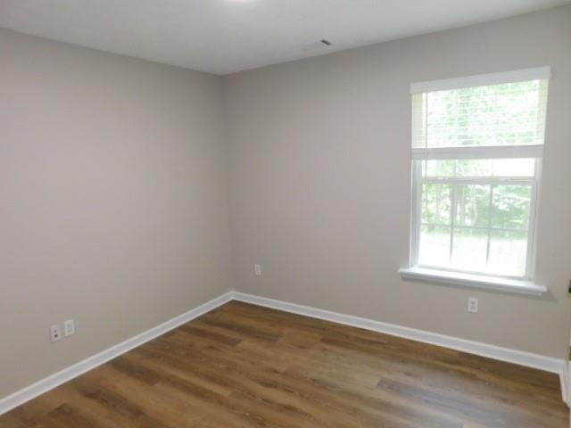 1834 Stephens Pond View Loganville, GA 30052 - Photo 18 of 25 an empty room with wooden floor and windows