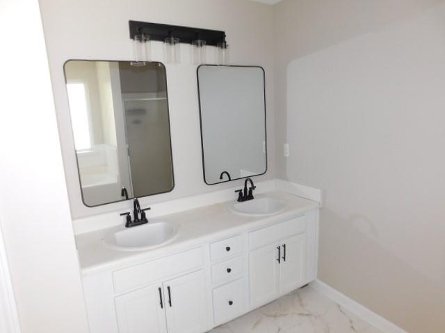 1834 Stephens Pond View Loganville, GA 30052 - Photo 23 of 25 a bathroom with a double vanity sink and mirror