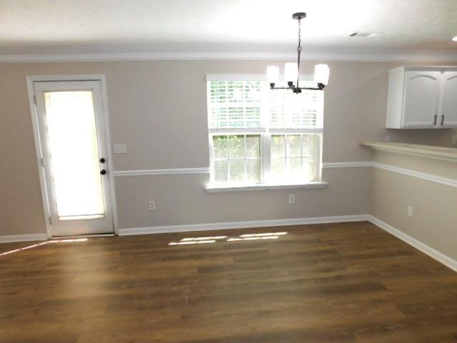 1834 Stephens Pond View Loganville, GA 30052 - Photo 9 of 25 an empty room with wooden floor chandelier and windows