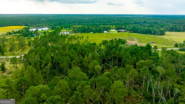 a view of field with grass and white house