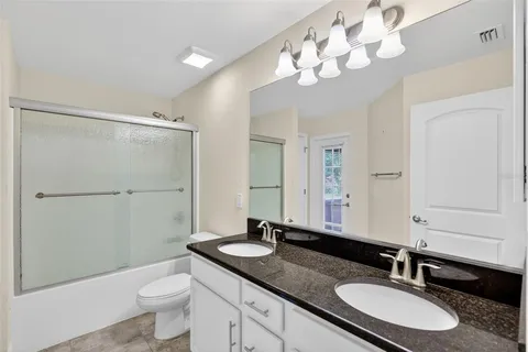 a bathroom with a granite countertop tub sink and mirror
