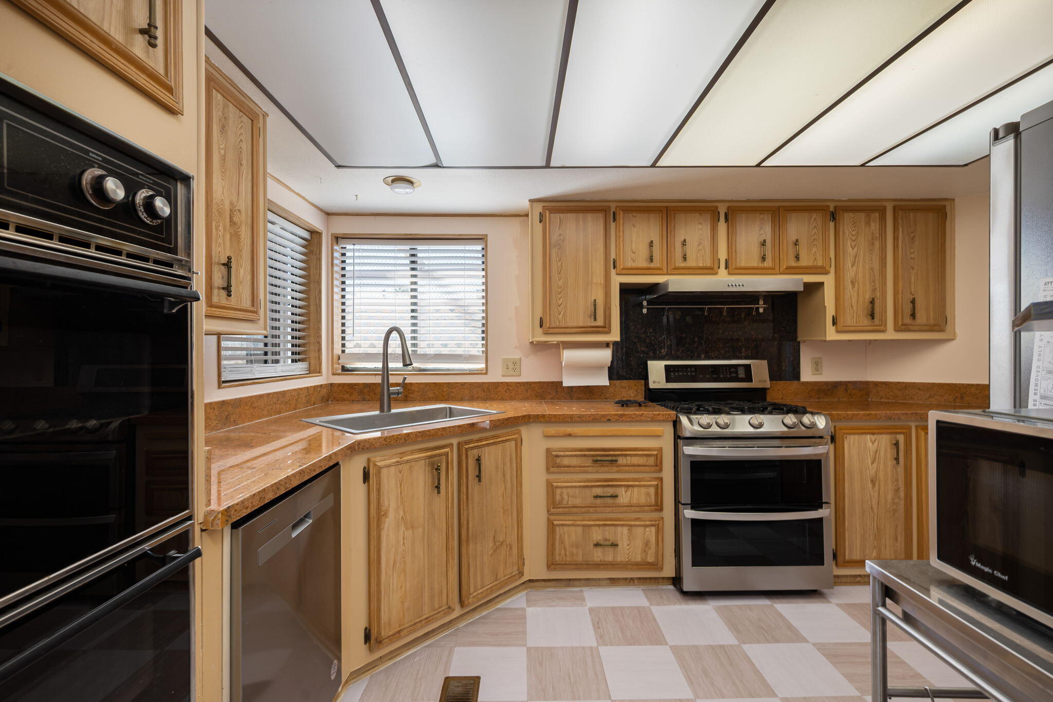 33204 Laredo Circle Thousand Palms, CA 92276 - Photo 27 of 62 a kitchen with stainless steel appliances granite countertop a stove microwave and sink