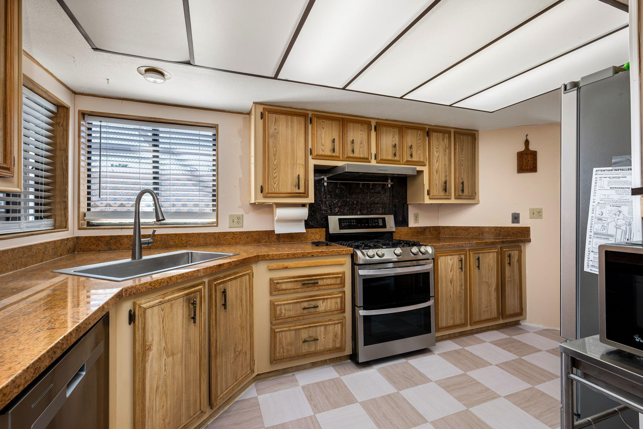 33204 Laredo Circle Thousand Palms, CA 92276 - Photo 28 of 62 a kitchen with stainless steel appliances granite countertop a stove a sink and a microwave