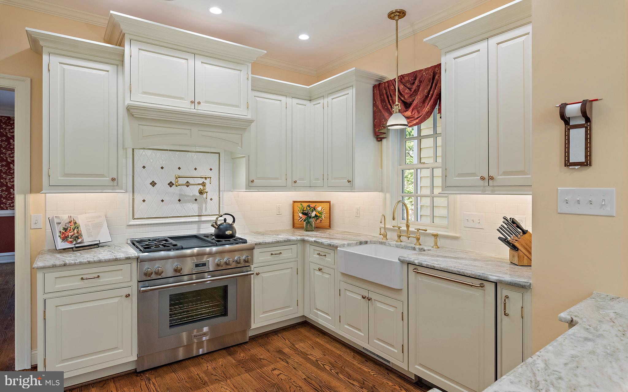 403 Beards Dock Crossing Annapolis, MD 21403 - Photo 34 of 96 a kitchen with a sink dishwasher stove and white cabinets with wooden floor