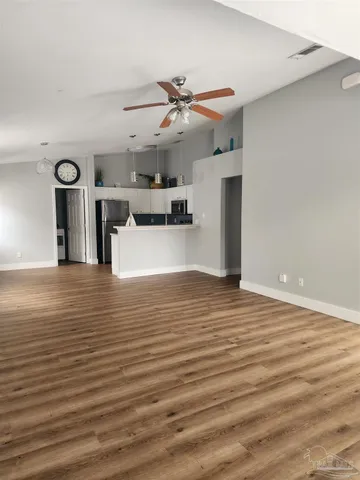 a view of a livingroom with a kitchen counter tops and a ceiling fan