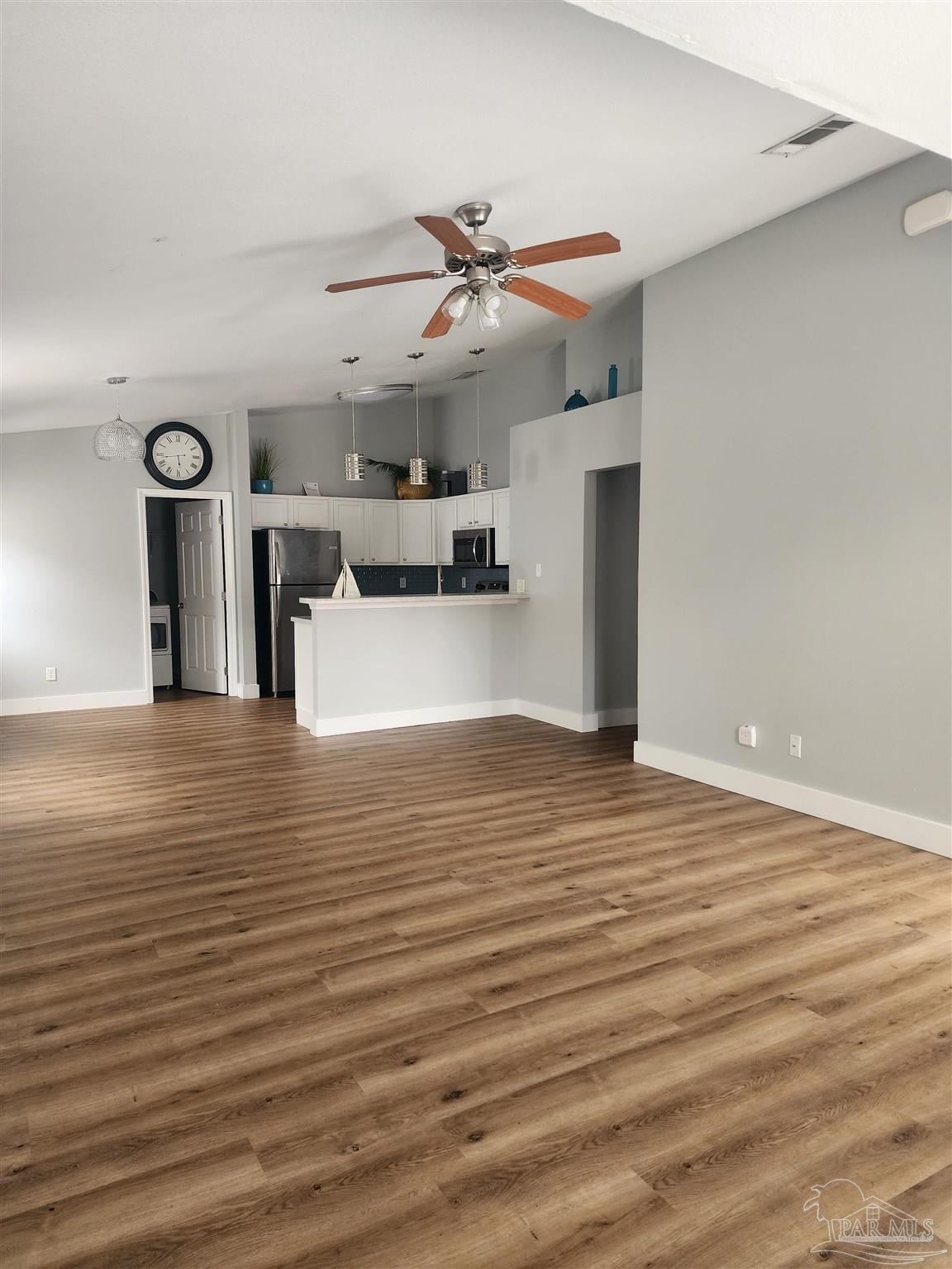 7447 Harvest Village Court Navarre, FL 32566 - Photo 13 of 27 a view of a livingroom with a kitchen counter tops and a ceiling fan