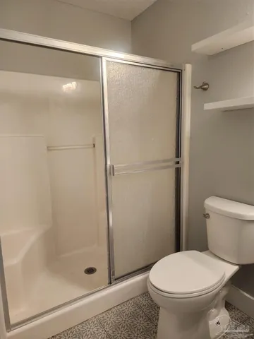 a bathroom with a toilet and a shower
