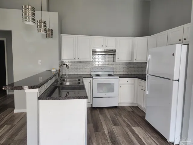 a kitchen with white cabinets and white appliances