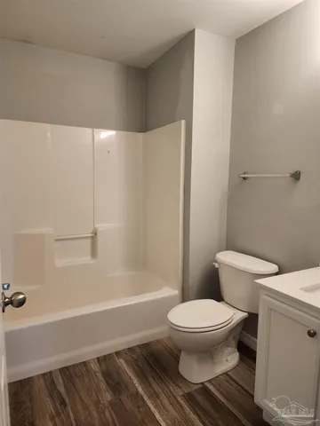 a white toilet sitting next to a bath tub