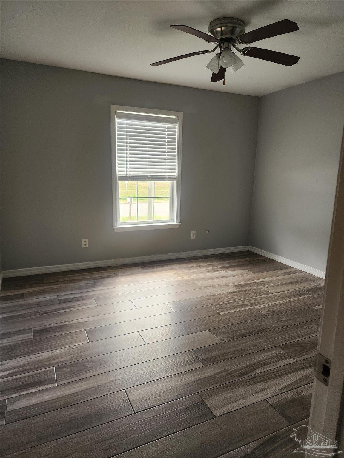 7447 Harvest Village Court Navarre, FL 32566 - Photo 22 of 27 wooden floor in an empty room with a window