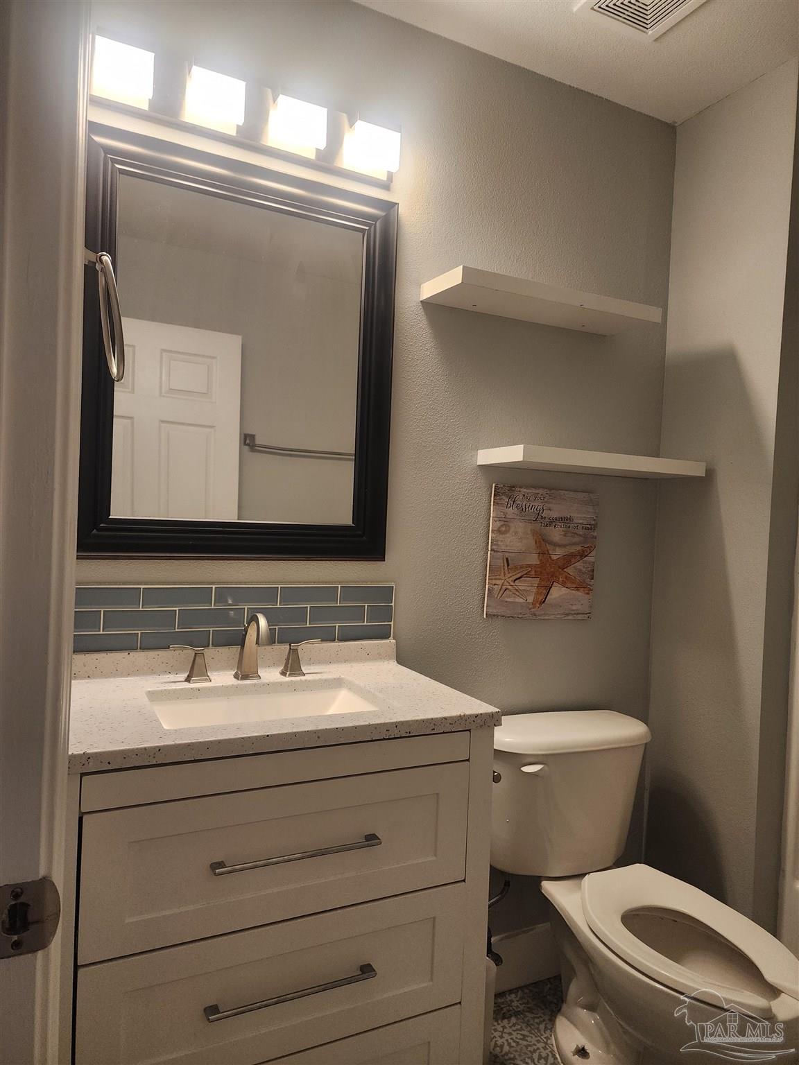 7447 Harvest Village Court Navarre, FL 32566 - Photo 4 of 27 a bathroom with a toilet sink and mirror