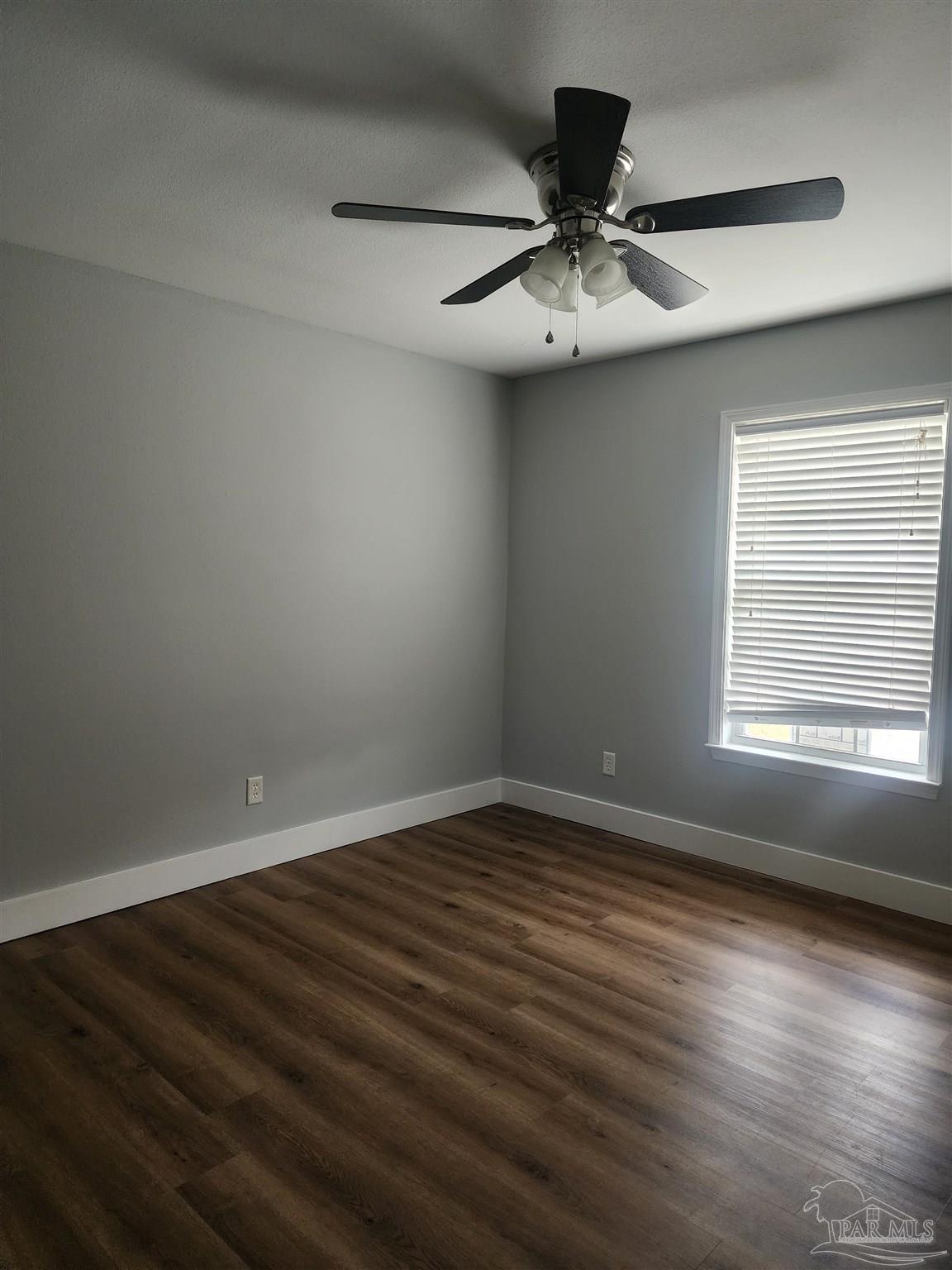 7447 Harvest Village Court Navarre, FL 32566 - Photo 7 of 27 an empty room with wooden floor fan and windows