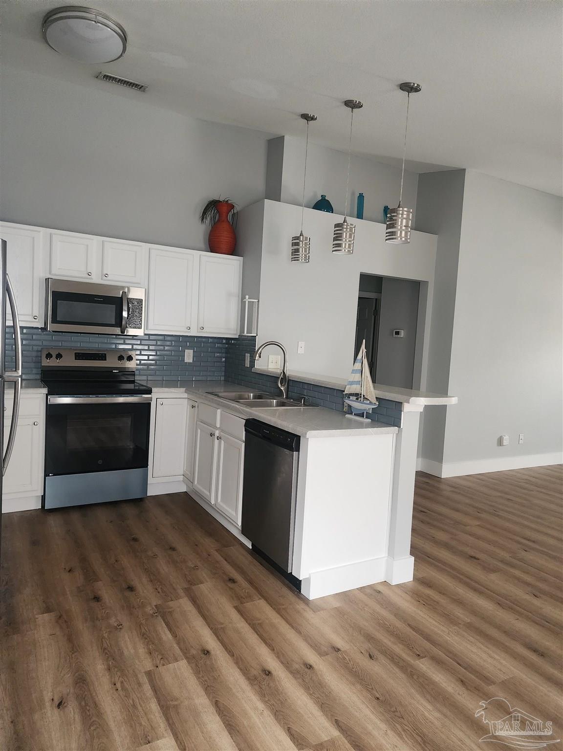 7447 Harvest Village Court Navarre, FL 32566 - Photo 10 of 27 a kitchen with granite countertop a sink and a stove top oven