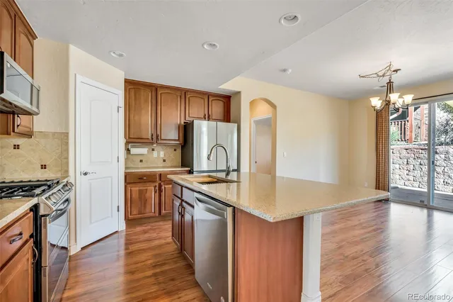 a kitchen with stainless steel appliances granite countertop a sink stove and refrigerator