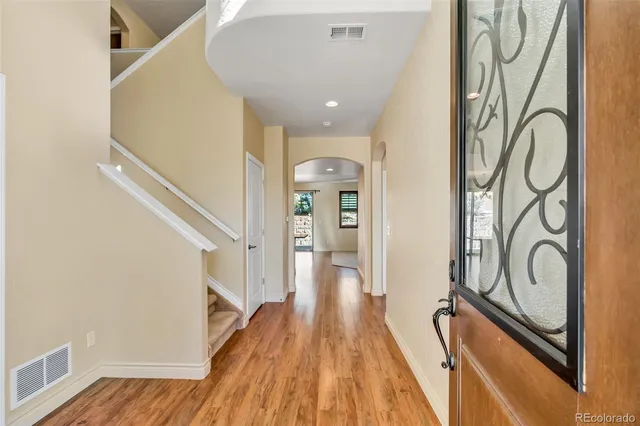 a view of a hallway with wooden floor and staircase