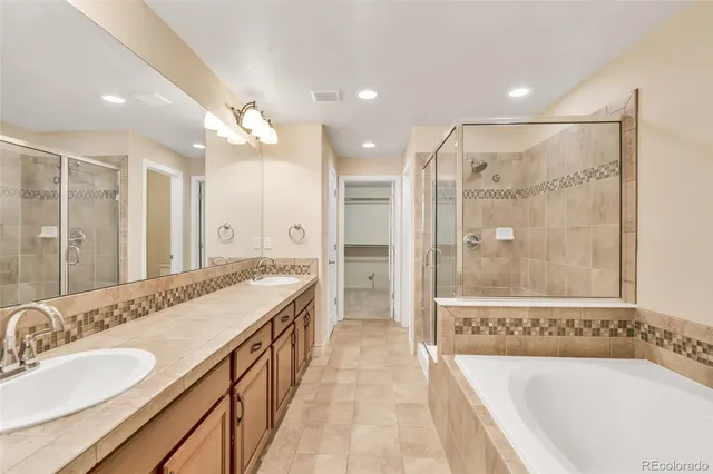 a bathroom with a bathtub shower sink mirror and toilet
