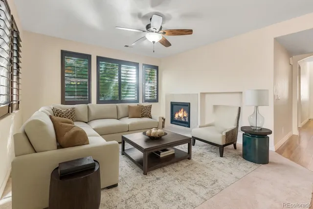 a living room with furniture a ceiling fan and a window