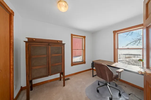 a view of a workspace with furniture and a window