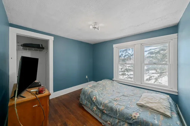a bedroom with a bed and a flat tv screen on the dresser